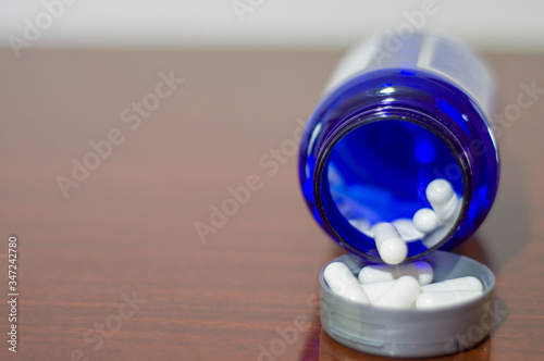 white vitamin pills, in blue pot, concept of health and body care