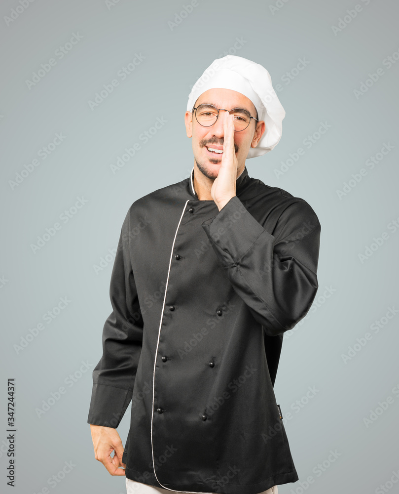 Happy young chef trying to say something strongly Happy young chef trying to say something strongly