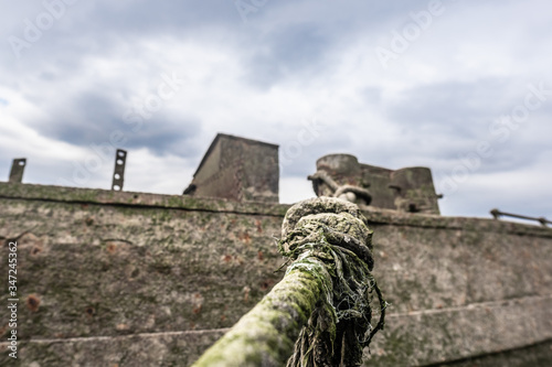 Hawser holding rusty, green tarnished boat