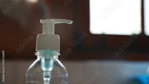 hand rub or sanitiser alcohol solution sprayed in to asian black hand in day time.