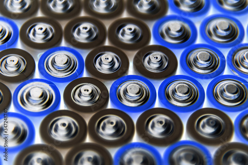 The batteries stand close together and form a beautiful background. Selective focus. Artistic blurring at the edges. Energy source. Patterns.