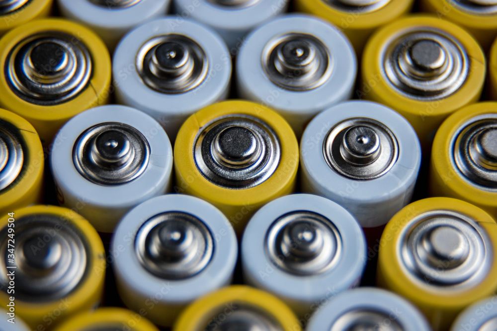 The batteries stand close together and form a beautiful background. Selective focus. Artistic blurring at the edges. Energy source. Patterns.