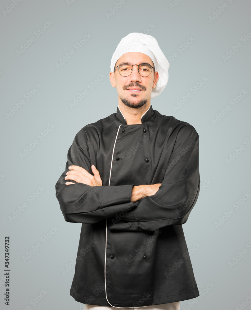 Satisfied young chef with crossed arms gesture Satisfied young chef with crossed arms gesture