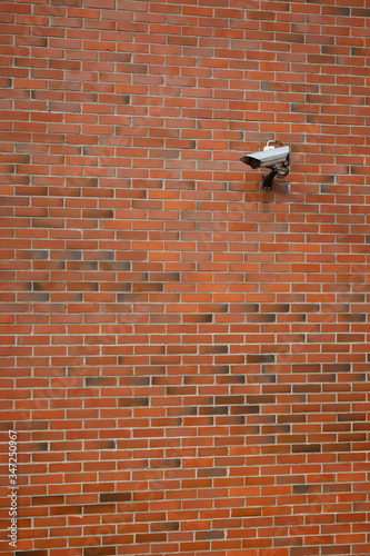 CCTV security surveillance camera mounted on a red brick wall.