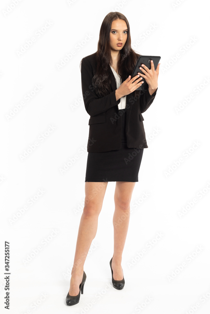 A young businesswoman stands with a tablet and checks important information on it. A young businesswoman stands with a tablet and checks important information on it.