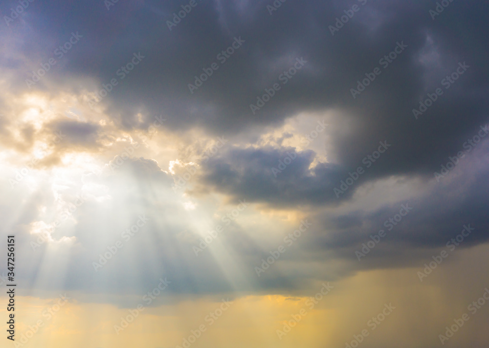 Low Angle View Of Sunlight Streaming Through Clouds