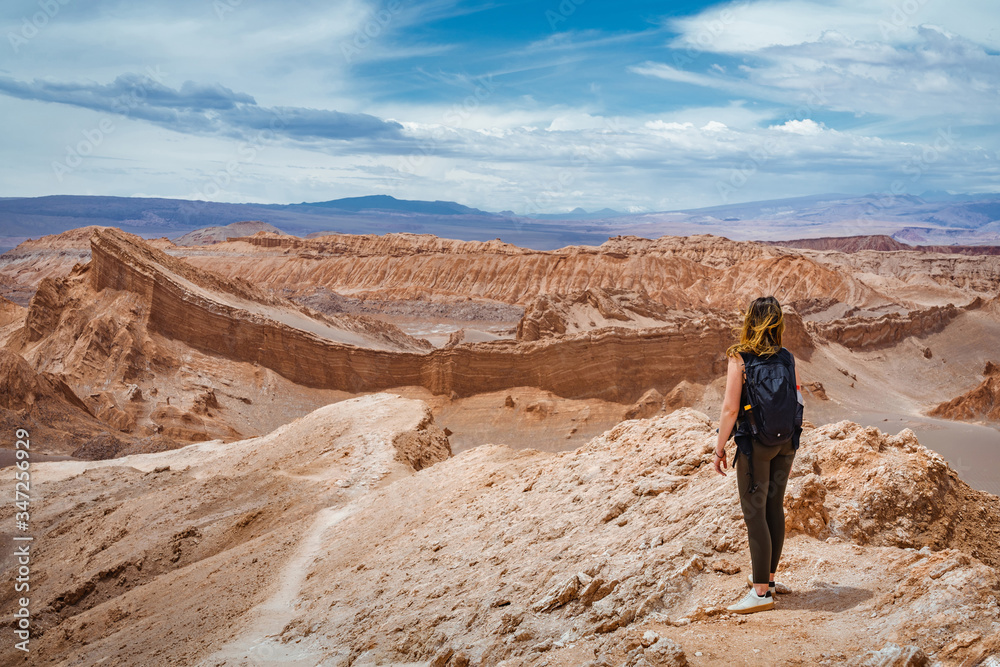 Young female traveller exploring the Moon Valley (Spanish: Valle de la Luna) in the Atacama Desert, northern Chile, South America.