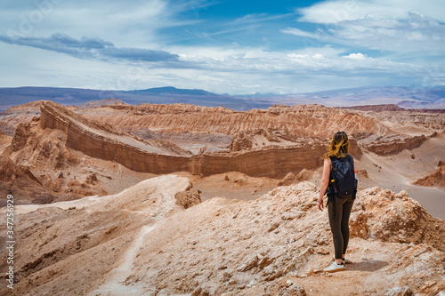 Young female traveller exploring the Moon Valley (Spanish: Valle de la Luna) in the Atacama Desert, northern Chile, South America.