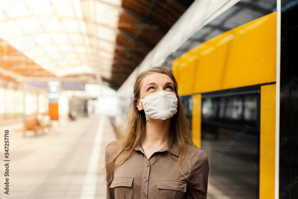 Woman wearing white protective face mask is using public transportation during the epidemic outbreak Woman wearing white protective face mask is using public transportation during the epidemic outbreak