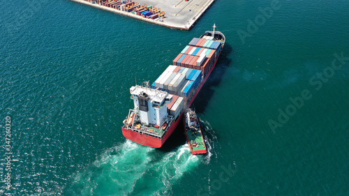 Aerial drone photo of tug boat assisting container cargo ship to dock to logistics international port © aerial-drone