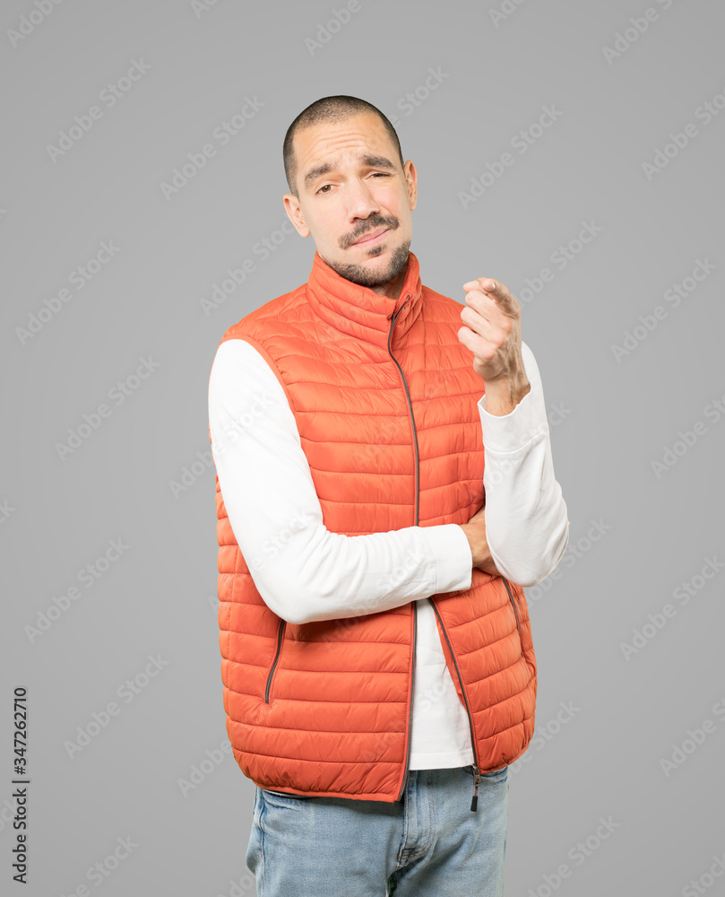 Hesitant young man pointing at you with his finger Hesitant young man pointing at you with his finger