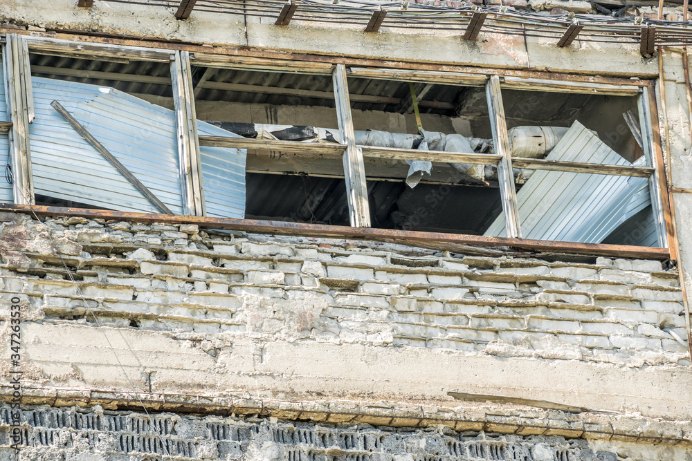 An old Industrial iron window frame rusting with broken glass.