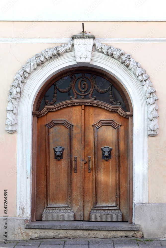 big wooden brown antique gates or doors. Wooden door with decoration elements in old building facade. Tallinn, Estonia