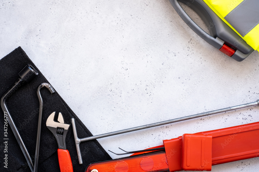 Naklejka premium car emergency kit - warning triangle danger sign, first aid kit and reflective vest, metal hook part of the Jack device.