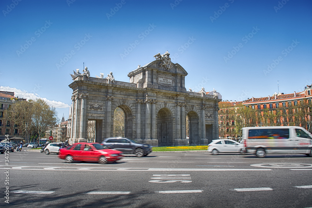 Puerta de Alcalá in summer with blurred cars.