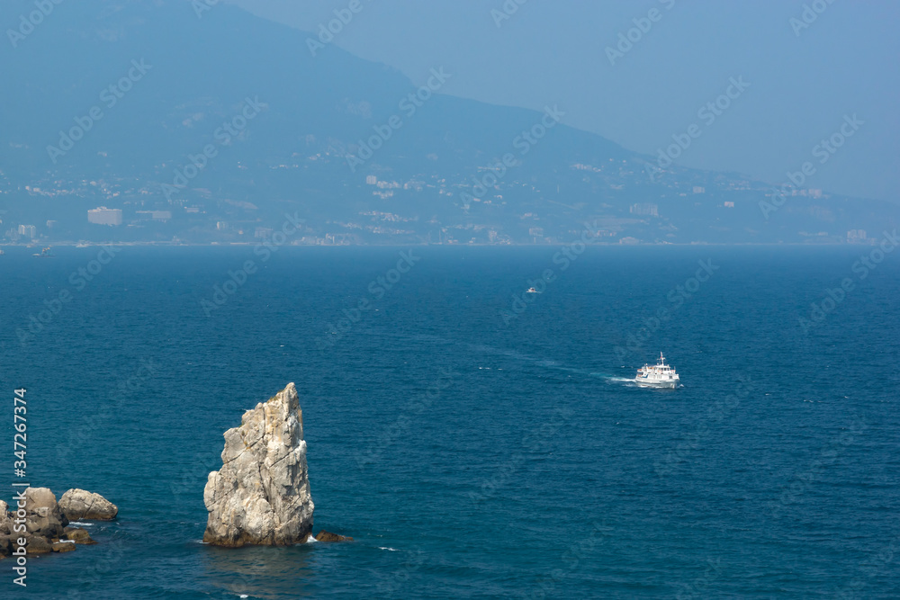 Panoramic view of the Black Sea coast. White ship on the turquoise water of the sea. Rock Sail, Yalta
