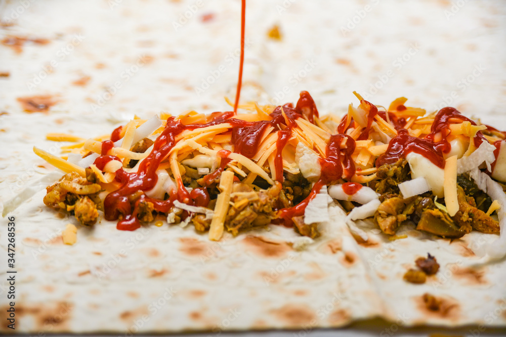 Ketchup is poured on cheese, cabbage and meat. Ketchup is poured on cheese, cabbage and meat.