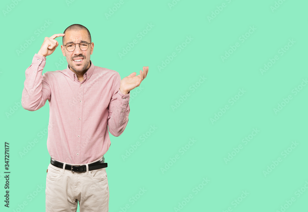 Concerned young man doing a gesture of confusion Concerned young man doing a gesture of confusion