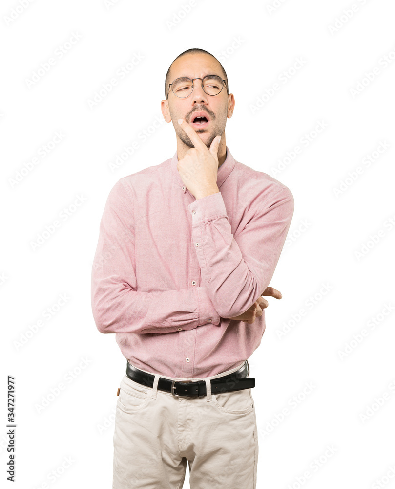 Concentrated young man making a gesture of distrust Concentrated young man making a gesture of distrust