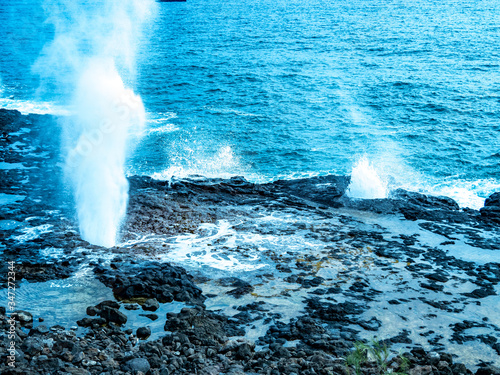 Lava blowholes in Hawaii. The ocean erodes the lava shelf underwater and then blows through holes in the top. photo