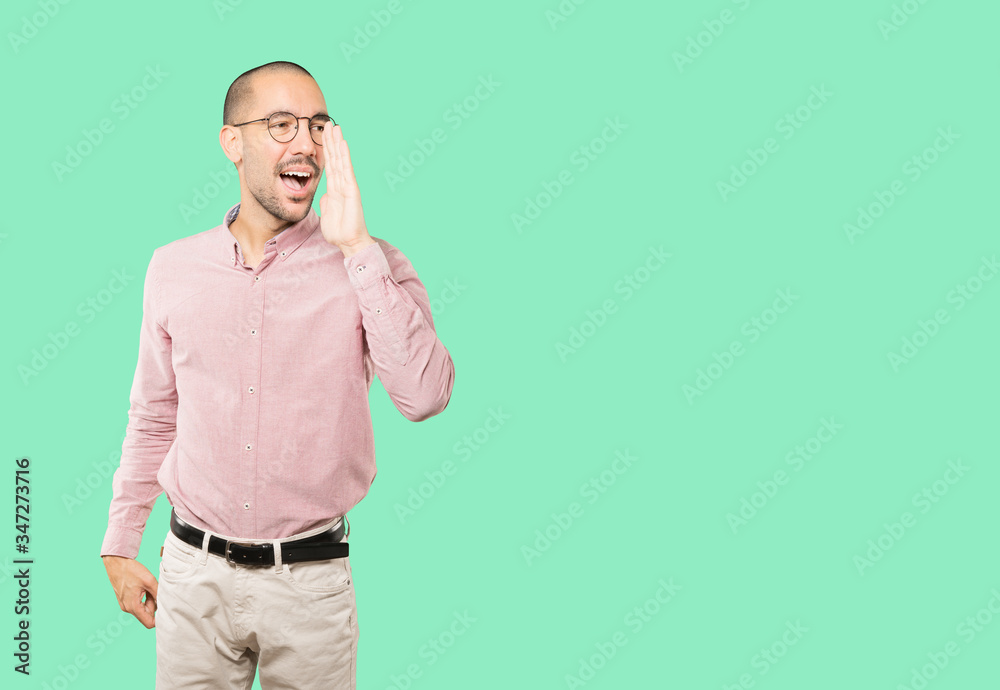 Happy young man trying to say something strongly Happy young man trying to say something strongly