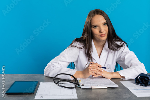 фотографія The doctor in the new office completes the medical documentation.