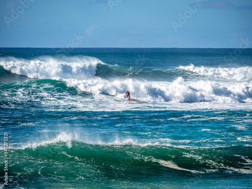 Surfers attempt to ride the big waves of Oahu's North Shore.