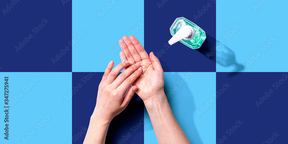 Fototapeta Applying sanitizer gel - healthcare and hygiene concept