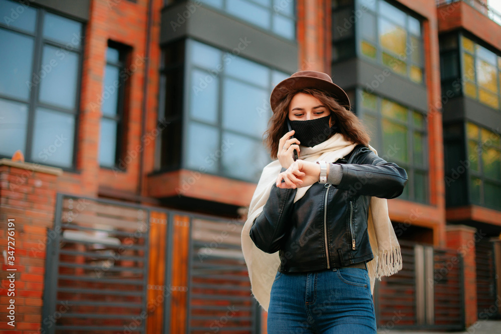 © Kateryna Ivaskevych - young woman with mobile phone in the city in mask. coronavirus. covid-19.
