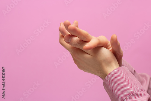The guy rubs his hands. pink background