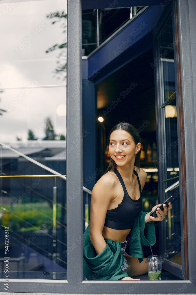 Beautiful girl in a cafe. Stylish girl in a green blouse. Lady near the window