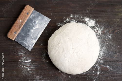 Freshly prepared yeast dough for health homemade bread on a gark brown wooden background. photo