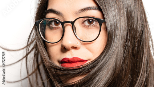 Portrait of young woman wearing eyeglasses and posing on camera