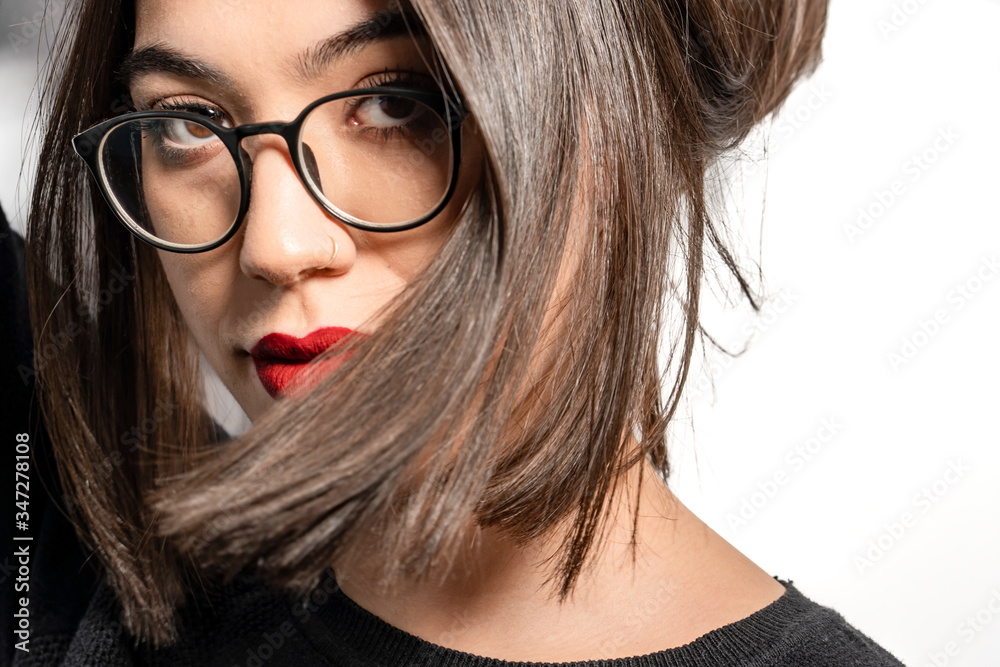 Fototapeta premium Portrait of young woman wearing eyeglasses and posing on camera