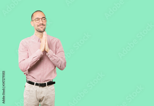 Happy young man praying gesture