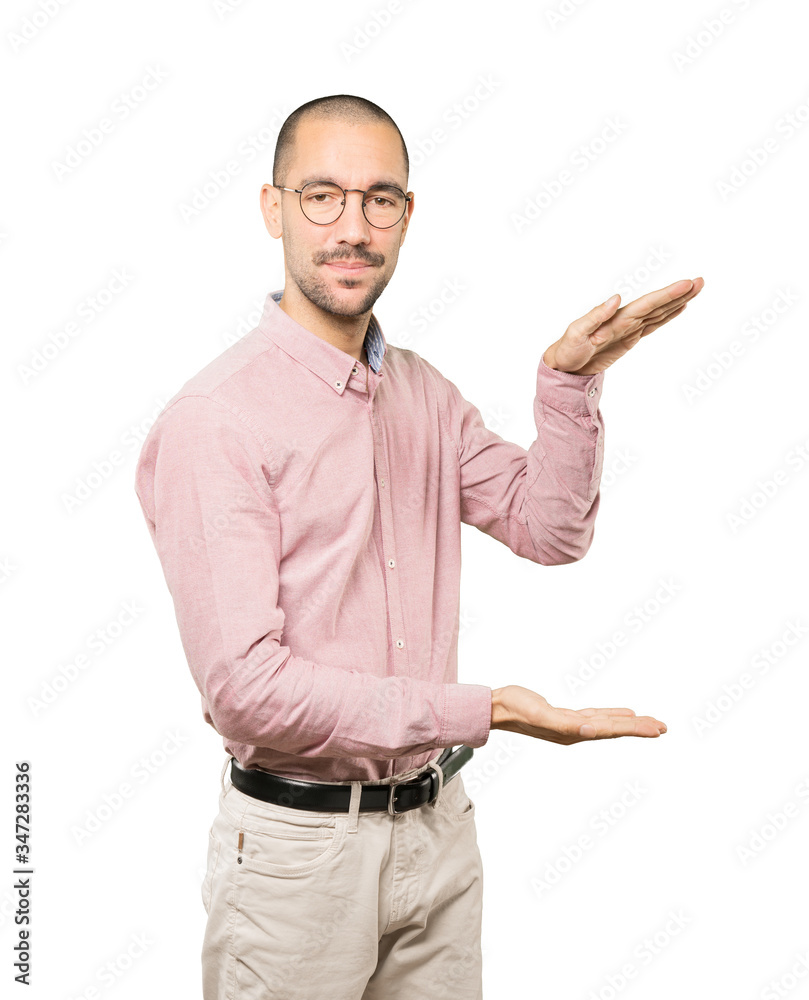 Confident young man doing a gesture of holding something with his hands Confident young man doing a gesture of holding something with his hands