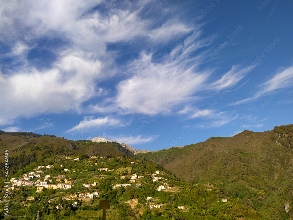 panoramic view of the Apuan Alps between the green mountains and the blue sea between the lush hills panoramic view of the Apuan Alps between the green mountains and the blue sea between the lush hills