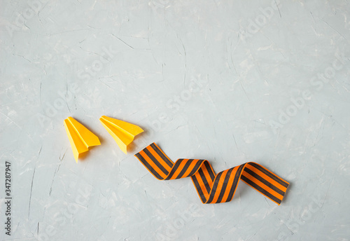 paper airplanes made of paper and St. George's ribbon in the form of a train from the plane on a gray background, top view, the concept of the victory day photo