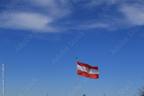 Austrian national flag is waving in the wind against blue sky background