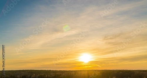 The time lapse of the winter landscape, a beautiful sky with clouds moving over the scenery, 4K, the rays of the sun shine through the clouds. olling cloud film photo