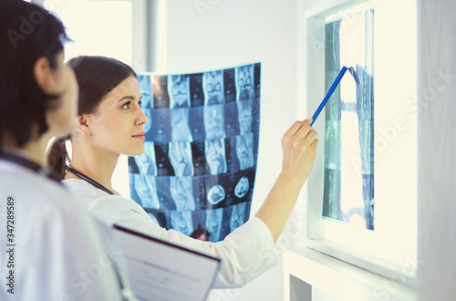 Two female doctors pointing at x-rays in a hospital