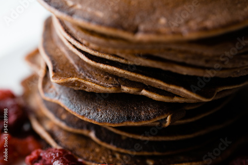 Close-up. A pile of chocolate fritters decorated with raspberries. The idea of a beautiful and delicious breakfast