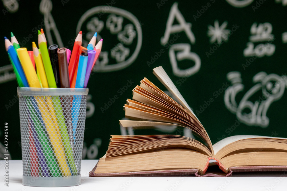 Back to school background with books, pencils and globe on white table on a green blackboard background. Back to school background with books, pencils and globe on white table on a green blackboard background.