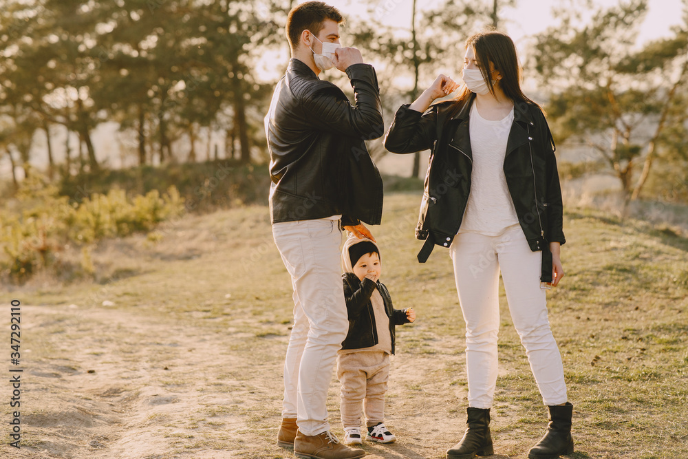 Obraz premium Family with cute little son. People in a summer field. Corona virus theme.