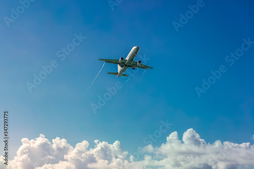 Plane landing with blue sky and white clouds as a background