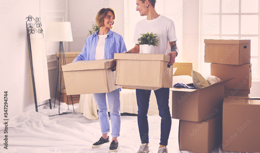 Couple holding boxes for moving the hands and looking inside box Couple holding boxes for moving the hands and looking inside box