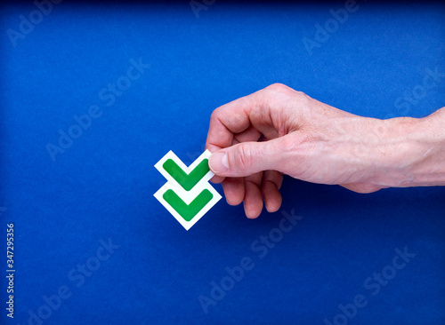 Flèche double verte tenue par une main ouverte pour illustrer la baisse