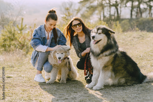 Women in a spring forest. Girls with cute dogs. Stylish friends walks. © prostooleh