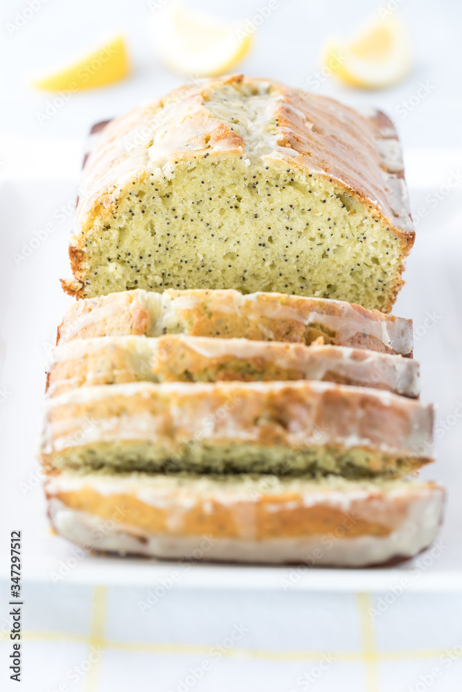 A front facing close up view of a lemon poppy seed loaf that has been sliced into. A front facing close up view of a lemon poppy seed loaf that has been sliced into.