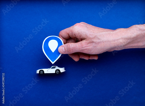 Illustration dessin voiture sport avec panneau de localisation tenu par une main d'homme isolé sur fond bleu